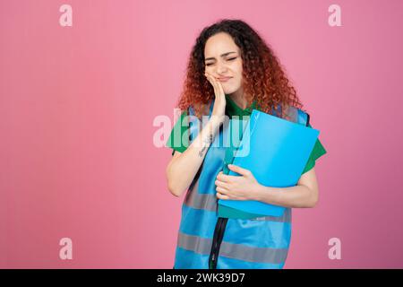 Bella donna in piedi con gli occhi chiusi, toccando chhek, posando in casa, avendo mal di denti. Foto Stock