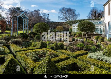 Shepherd House Garden, Inveresk, East Lothian, Scozia, Regno Unito 18 febbraio 2024. Scotland's Garden Scheme Snowdrop Weekend: Il giardino è aperto al pubblico con donazioni d'ingresso destinate a beneficenza. Nella foto: Il giardino formale ha molte caratteristiche ornamentali. Crediti: Sally Anderson/Alamy Live News Foto Stock