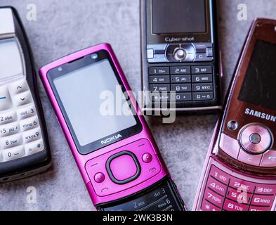 Assortimento di telefoni cellulari vintage dei primi anni '2000 su una superficie ruvida Foto Stock