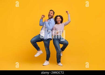 Buona fortuna. Felicissimi Black Man e Woman che allevano pugni e esclamano Foto Stock