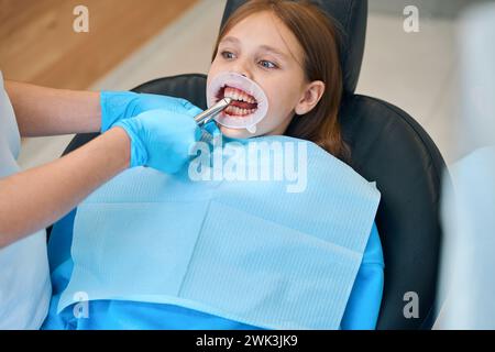 Procedura per la rimozione di un dente per bambini con un attrezzo speciale Foto Stock