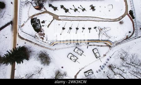 Vista aerea di carri armati ricoperti di neve, artiglieria e un jet fighter nella Cittadella di Poznań durante l'inverno, fucilati da un drone. Foto Stock