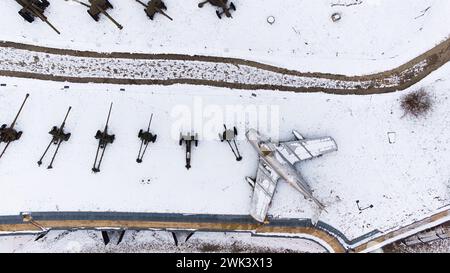 Vista aerea di carri armati ricoperti di neve, artiglieria, veicoli corazzati, veicoli militari e aeroplani nella Cittadella di Poznan durante l'inverno, fucilati da un drone. Foto Stock