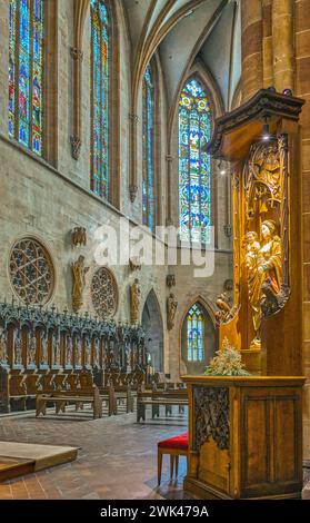 Colmar, Francia - 21 settembre 2022: Il coro di legno con una statua sacra in primo piano della chiesa di San Martin Collegiate Church Foto Stock