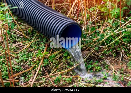 Vista a livello primo piano su un tubo di scarico a terra con flusso lento Foto Stock