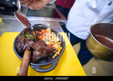 Cuocere prepara la carne con verdure e salsa per servire Foto Stock