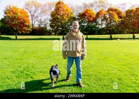 Un vecchio che cammina con il suo cane nel parco Foto Stock