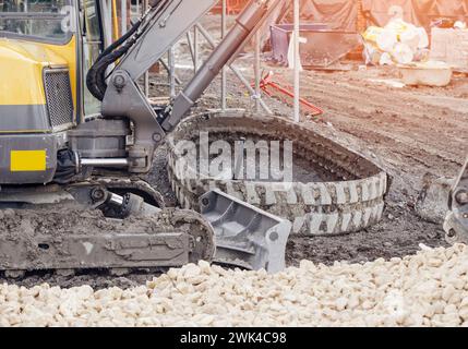 Escavatore rotto senza binari in cantiere in attesa di riparazione Foto Stock