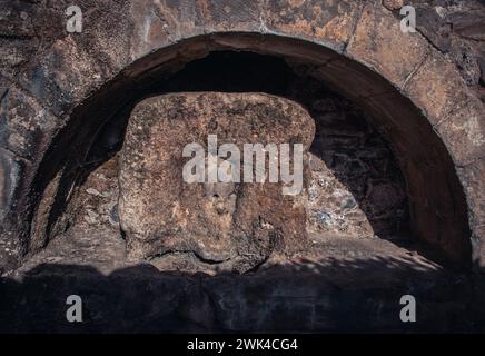 Vecchia fontana d'acqua di strada con la foto del volto della donna. Mascaron nella nicchia del muro di pietra. Fotografia del monastero di Sant Miquel del fai. Immagini di alta qualità Foto Stock