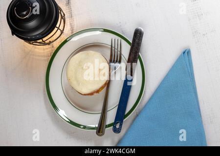 Panino alla cannella, chicchi di caffè, lampada su tavolo in legno Foto Stock