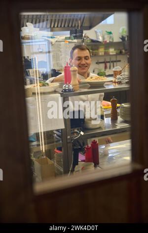 L'uomo mette una porzione di cibo su uno scaffale Foto Stock