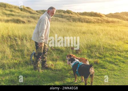 Un vecchio che cammina con il suo cane nel parco Foto Stock