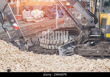 Escavatore rotto senza binari in cantiere in attesa di riparazione Foto Stock