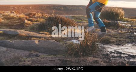 Donna energica che cammina con stivali impermeabili lungo il percorso di trekking con figliuolo congelato nella fredda mattina d'inverno Foto Stock