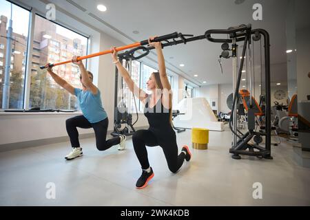 Donna e uomo di mezza età si stanno riscaldando con un bastone speciale Foto Stock