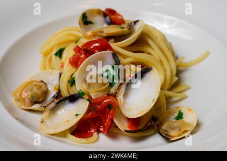 Spaghetti alle Vongole, pasta italiana o veneziana con vino bianco, pomodori e prezzemolo Foto Stock