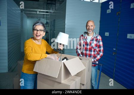 Lady prende le sue cose piegate fuori da una scatola Foto Stock