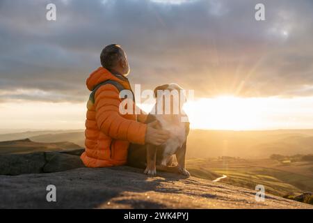 vecchio uomo maturo escursioni in montagna con il suo cane, esercizio fisico e fitness per il benessere, stile di vita sano e sorriso. Faccia di un signore anziano e maturo Foto Stock