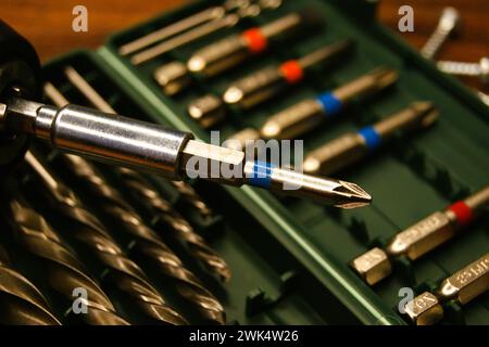 Primo piano di un cacciavite a batteria sullo sfondo di un set di punte Foto Stock