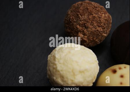 Varie caramelle al cioccolato su sfondo scuro. Primo piano Foto Stock