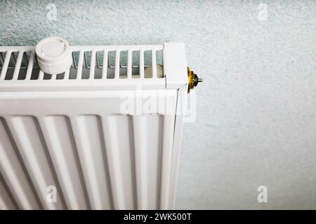 Riscaldamento centralizzato in un edificio moderno ben tenuto. Sensore di regolazione del riscaldatore per modificare la temperatura. Foto Stock