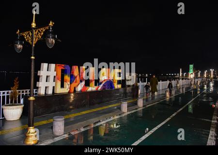 Srinagar, Kashmir, India. 18 febbraio 2024. I residenti camminano lungo la strada durante le piogge a Srinagar, la capitale estiva di Jammu e Kashmir. Sono state segnalate nevicate fresche nei tratti più alti del Kashmir, mentre le pianure hanno subito piogge, con un conseguente calo significativo delle temperature.l'ufficio meteorologico ha previsto nevicate da moderata a pesante o precipitazioni attraverso la valle del Kashmir per i prossimi tre giorni. (Immagine di credito: © Saqib Majeed/SOPA Images via ZUMA Press Wire) SOLO PER USO EDITORIALE! Non per USO commerciale! Foto Stock