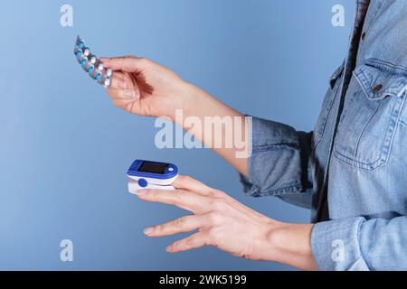 Donna che esegue l'autotest per i livelli di ossigeno nel sangue dal pulsossimetro Foto Stock