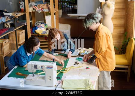 Vista dall'alto su gruppi diversi di ragazze che cucono vestiti insieme in una scuola inclusiva Foto Stock