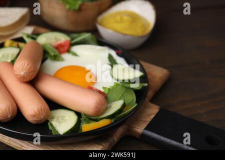 Colazione deliziosa con salsicce bollite e uova fritte servite su un tavolo di legno e da vicino Foto Stock