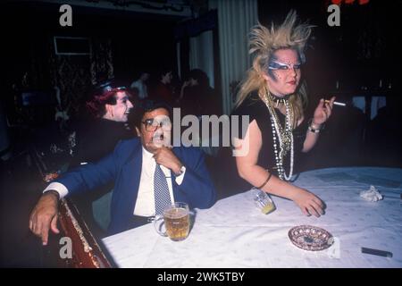 Titanic Club Londra anni '1980 Regno Unito. Nuova donna punk romantica con un uomo d'affari asiatico che sembra fuori posto in questo nightclub. Sta bussando su un bicchiere di succo. Inghilterra 1983 HOMER STKES. Foto Stock