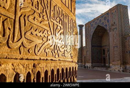 Iscrizioni coraniche accolgono i visitatori della Madrasa Tilla Kari, Samarcanda, Uzbekistan Foto Stock