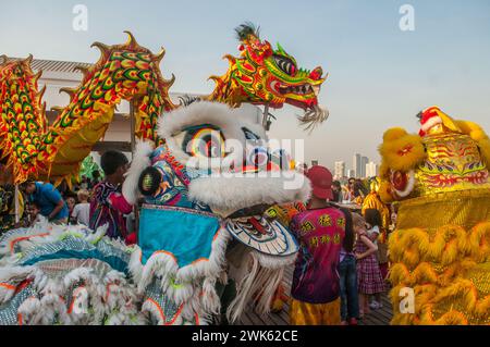 Danze di draghi e leoni contemporaneamente in uno skybar per il capodanno cinese, "l'anno del drago". Phnom Penh, Cambogia. Febbraio 2024. © Kraig Lieb Foto Stock