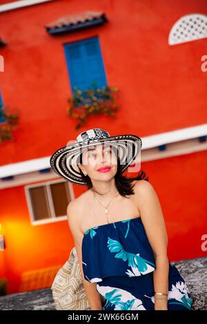 Bella donna che indossa il tradizionale cappello colombiano chiamato Sombrero Vueltiao nelle strade storiche della città fortificata di Cartagena de Indias Foto Stock