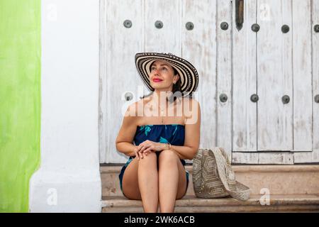 Bella donna che indossa il tradizionale cappello colombiano chiamato Sombrero Vueltiao nelle strade storiche della città fortificata di Cartagena de Indias Foto Stock