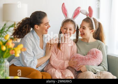 Buone vacanze. Madre e le sue figlie. La famiglia festeggia la Pasqua. Le bambine adorabili indossano orecchie da coniglio. Foto Stock