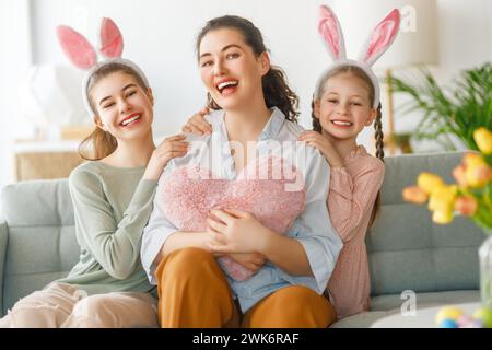 Buone vacanze. Madre e le sue figlie. La famiglia festeggia la Pasqua. Le bambine adorabili indossano orecchie da coniglio. Foto Stock