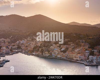 Isola di Symi, Grecia. Vacanze nelle isole della Grecia da Rodi nel Mar Egeo. Case colorate in stile neoclassico nella baia di Symi. vista della baia principale dell'isola, dove attraccano traghetti turistici e yacht Foto Stock