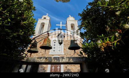 Tre campane di fronte a un muro di pietra sotto un cielo blu profondo, Koroni, fortezza bizantina, convento, Peloponneso, Grecia Foto Stock