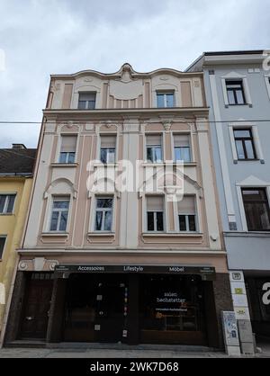 Un edificio moderno con numerose finestre, fiancheggiato da due strutture vicine: Linz, Austria Foto Stock