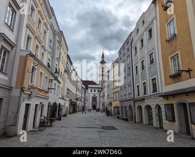 Una strada acciottolata che conduce ad un'alta torre dell'orologio: Linz, Austria Foto Stock