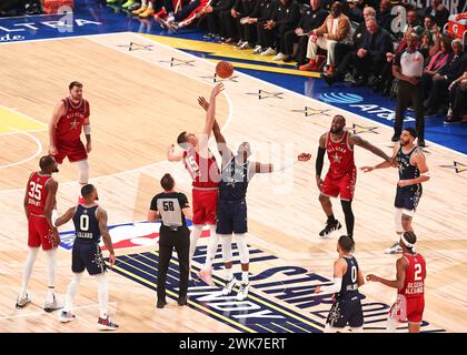 Indianapolis, Stati Uniti. 18 febbraio 2024. Nikola Jokic (C-L) dei Denver Nuggets della Western Conference e Bam Adebayo (C-R) dei Miami Heat della Eastern Conference hanno dato una punta alla partita durante l'NBA All-Star 2024 Game a Indianapolis, negli Stati Uniti, il 18 febbraio 2024. Crediti: Joel Lerner/Xinhua/Alamy Live News Foto Stock