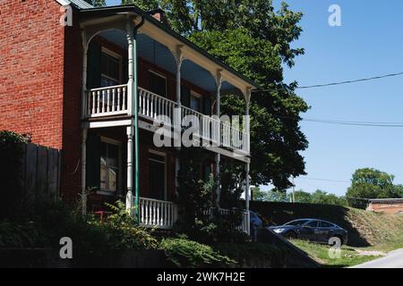 Casa in mattoni rossi con balconi su un lato e un balcone bianco sull'altro: Harper's Ferry, West Virginia Foto Stock