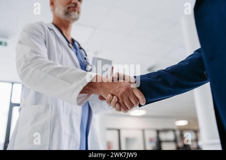 Primo piano di un rappresentante di vendita farmaceutico in studio medico, che stringe la mano. Direttore dell'ospedale, direttore della clinica medica privata greetin Foto Stock