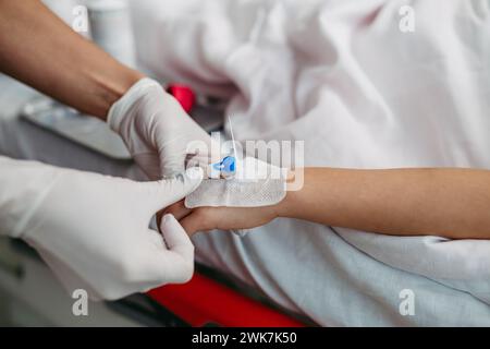 Primo piano dell'infermiera che inserisce la cannula IV in vena, mano di una bambina. IV, terapia endovenosa per pazienti pediatrici. Foto Stock