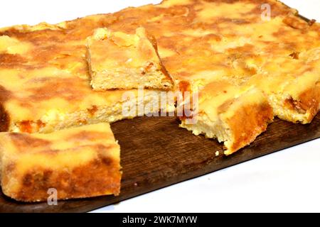 Primo piano di una casseruola distesa sul tavolo, tagliata a pezzi, ricavata dal formaggio fresco e dalla zucca. Foto Stock