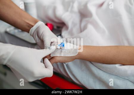 Primo piano dell'infermiera che inserisce la cannula IV nella mano di una bambina. IV, terapia endovenosa per pazienti pediatrici. Foto Stock
