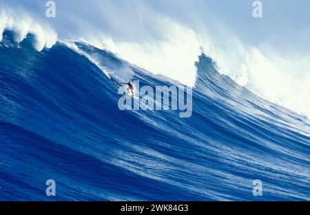 Uomo che naviga su un'onda enorme al largo della costa di Oahu, Hawaii Foto Stock