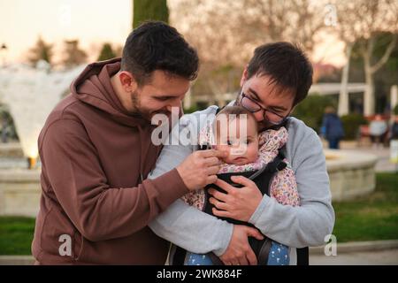 Coppia omosessuale felice che gioca con il loro bambino in un portabicchieri. Foto Stock