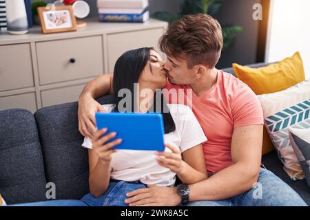 Coppia uomo e donna che si baciano a casa con il touchpad Foto Stock