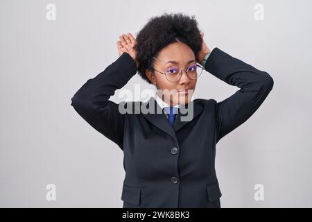 Bella donna africana con capelli ricci che indossa giacca da lavoro e occhiali che fanno un gesto con le mani palme che sembrano ciniche e scettiche. e Foto Stock